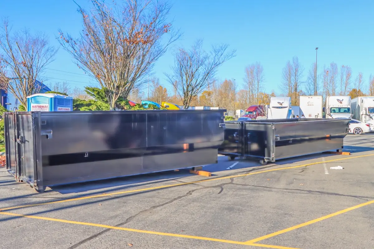 Professional dumpster rental service with roll-off container on residential driveway in Heath